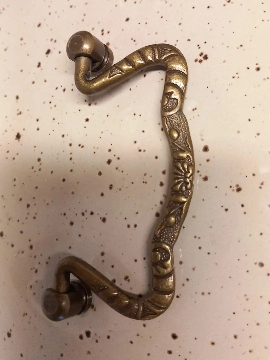 Kapak üzerindeki kabartma çiçek motifli pirinç kulpun yakın planı
