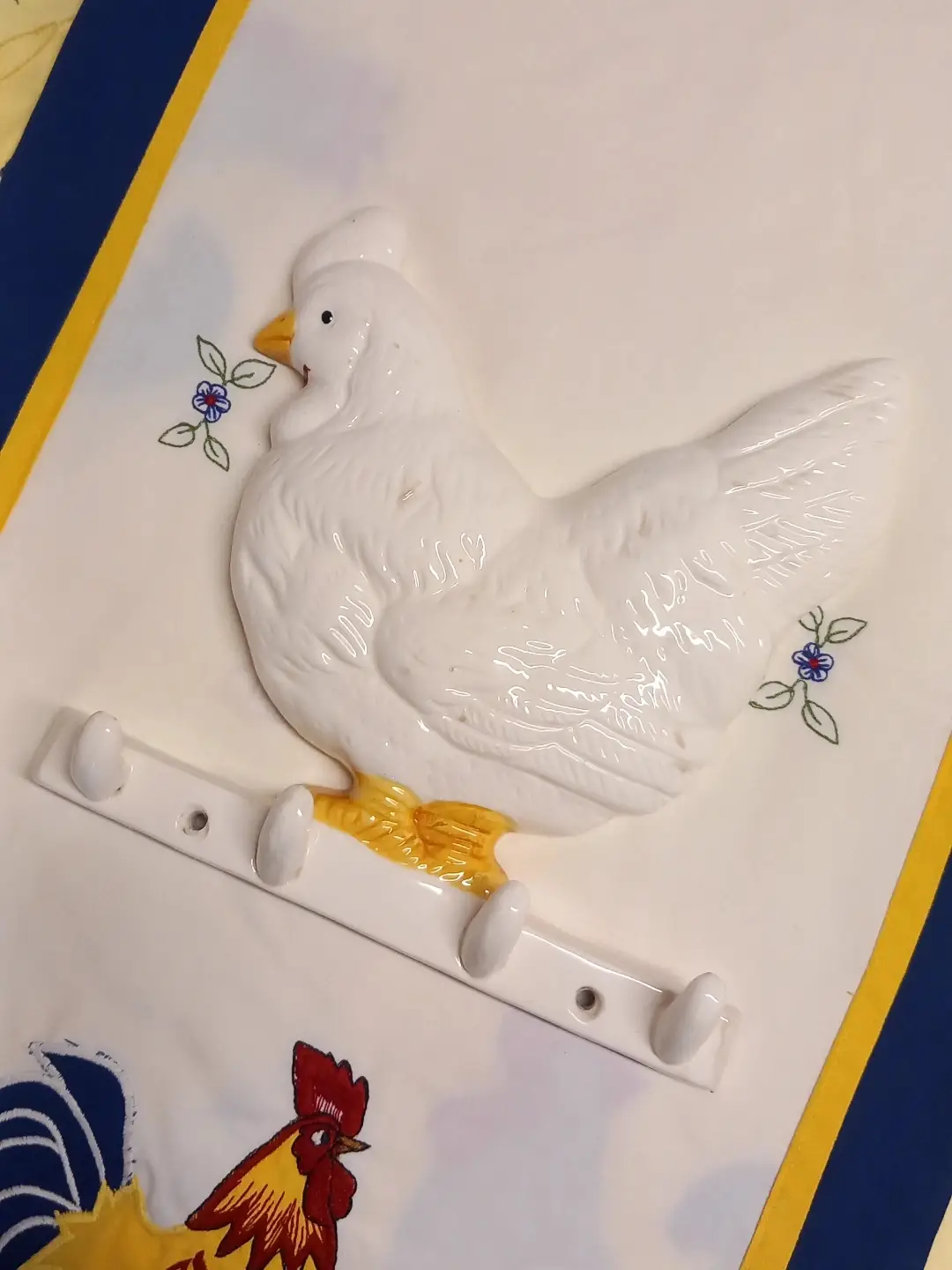 Tavuk figürlü seramik askılığın açılı görünümü; vida delikleri ve dört askı