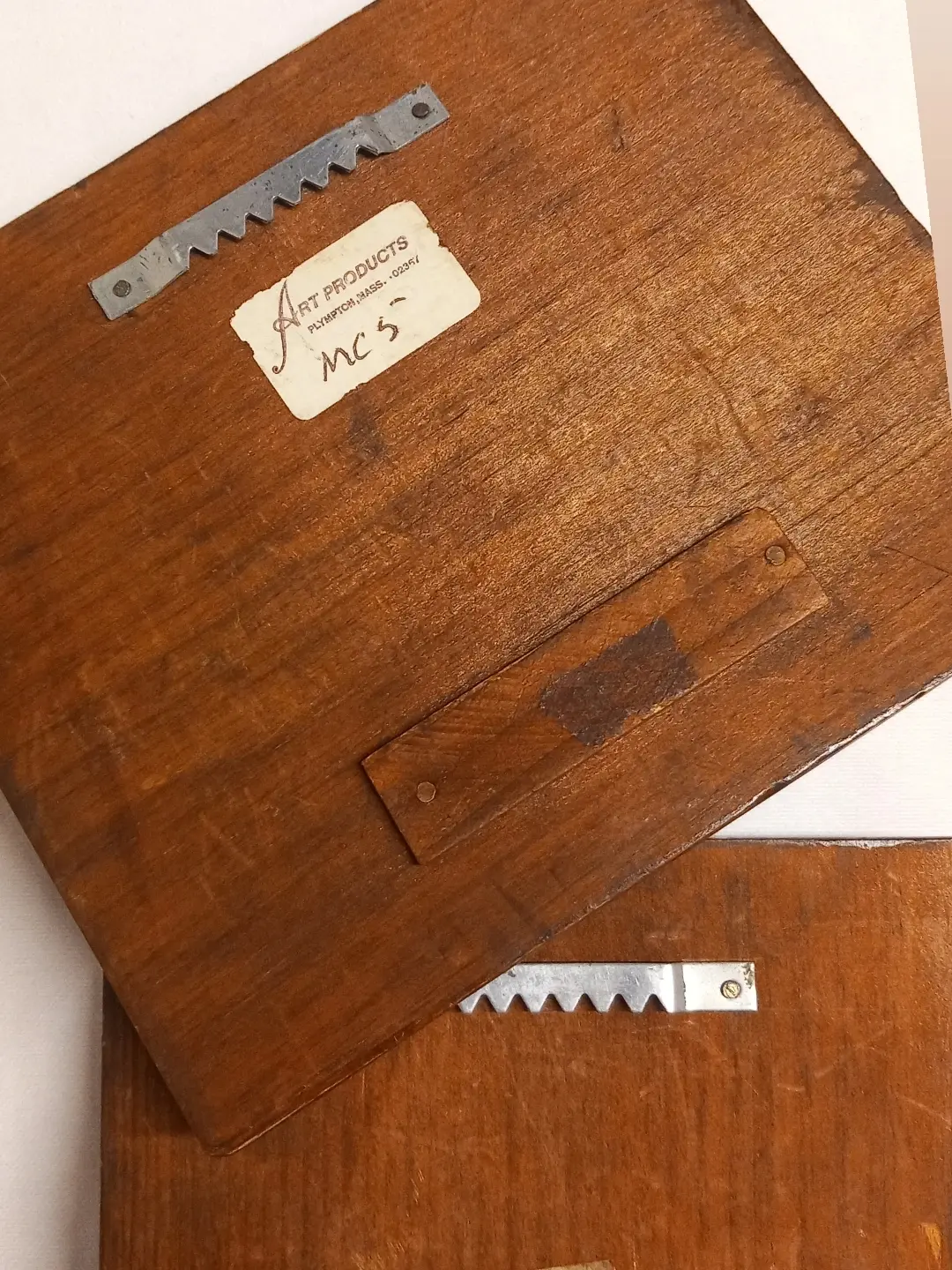 Panonun arkasındaki 'Art Products – Plympton, Mass.' etiketi ve testere dişli metal askı