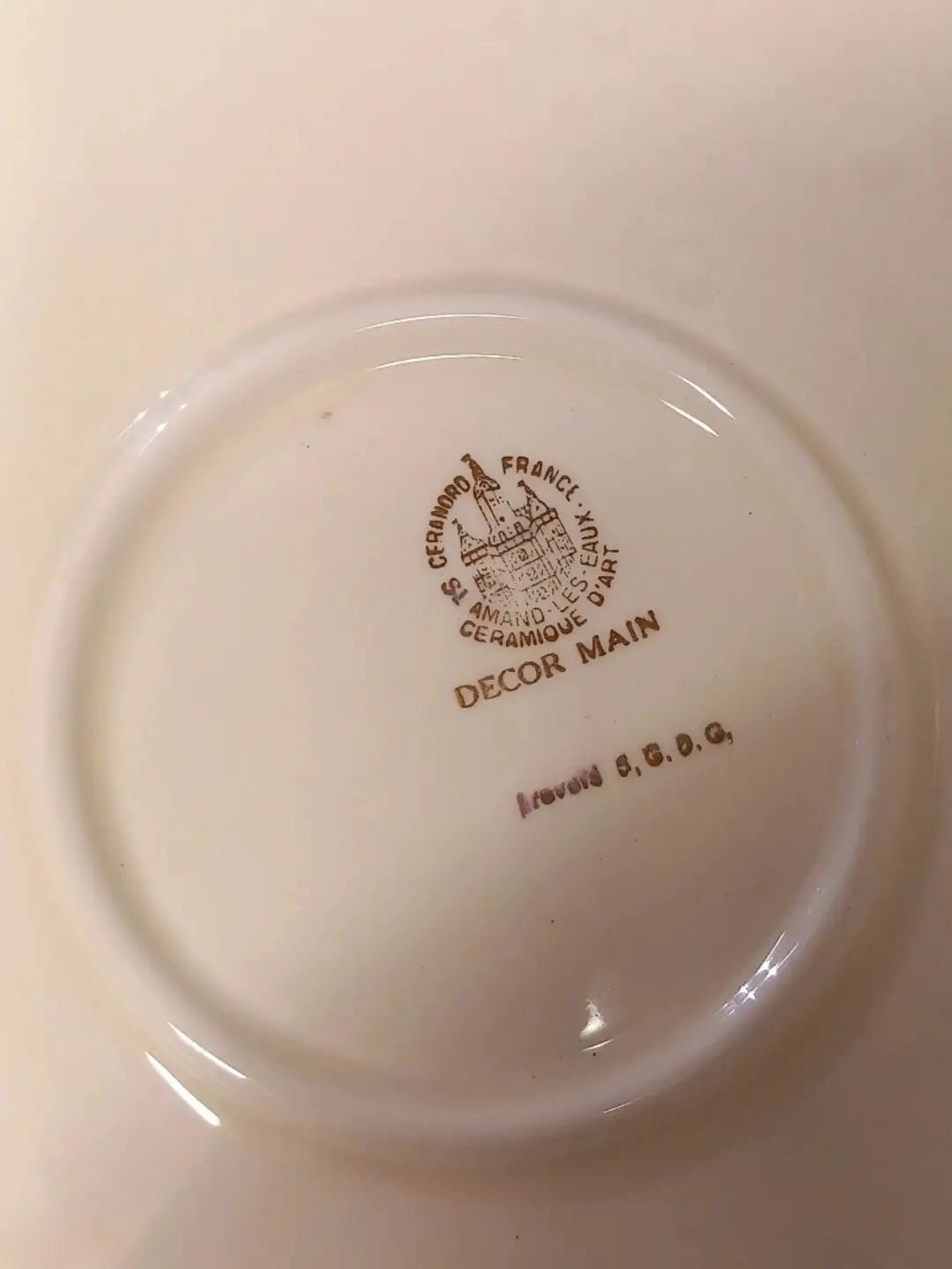 Tabağın arkasında kale motifli Ceranord St. Amand-les-Eaux damgası ve 'Decor Main' yazısı