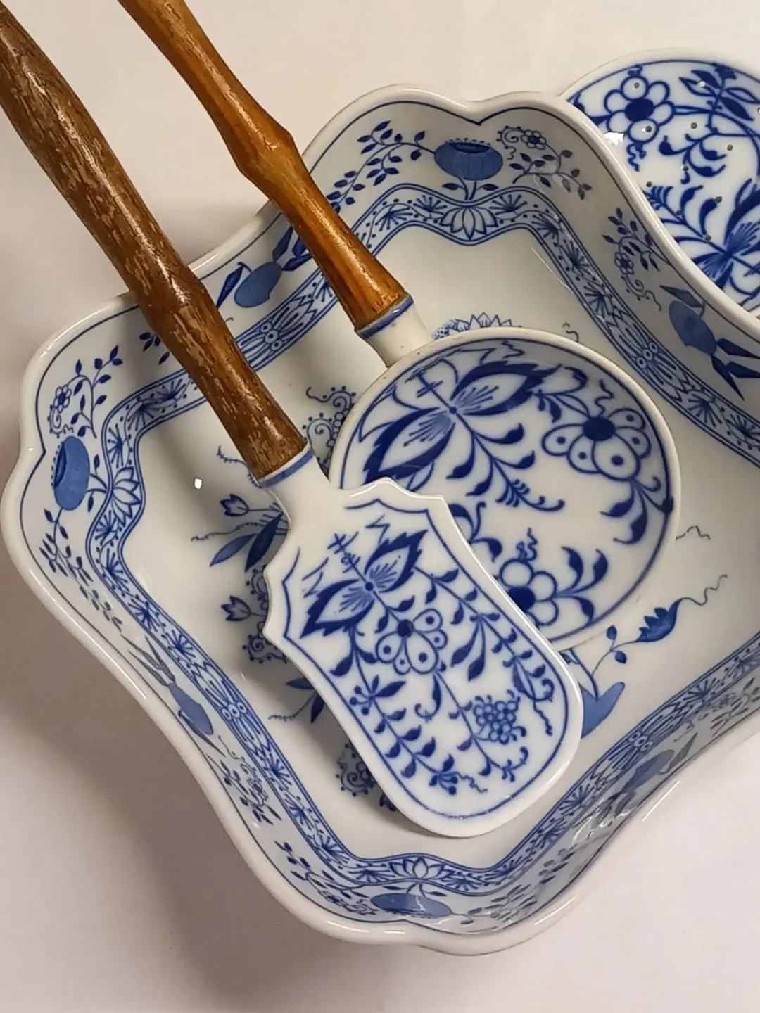Spatula ve yuvarlak formlu mavi-beyaz porselen servis parçalarının üstten yakın planı