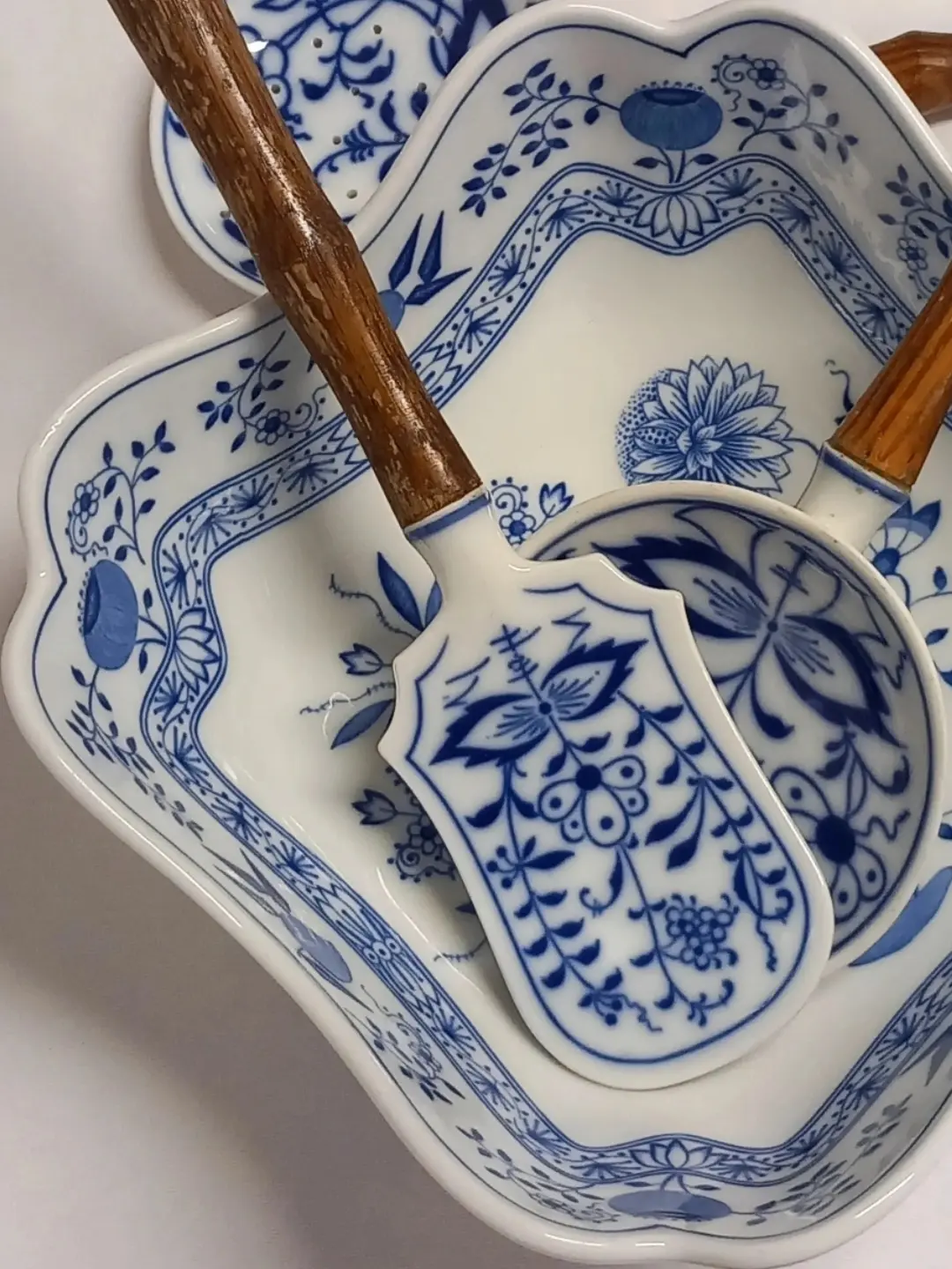 Mavi soğan desenli spatula ucunun ve aşınmış ahşap sapının yakın planı
