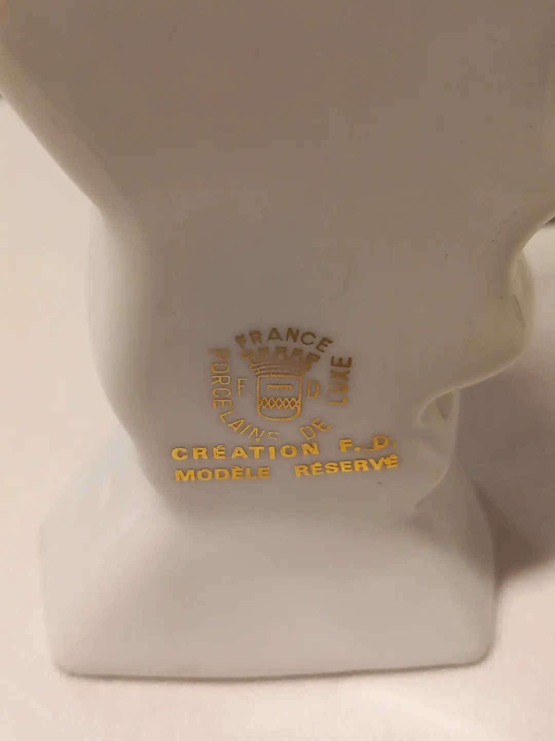 Şişenin tabanına yakın altın baskılı 'Porcelaine de Luxe – Création F.D. – Modèle Réservé' damgası