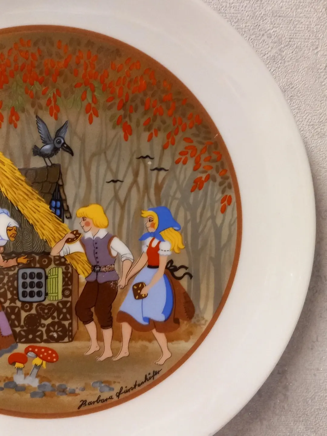 El ele duran Hansel ile Gretel ve sağ alttaki sanatçı imzasının yakın planı