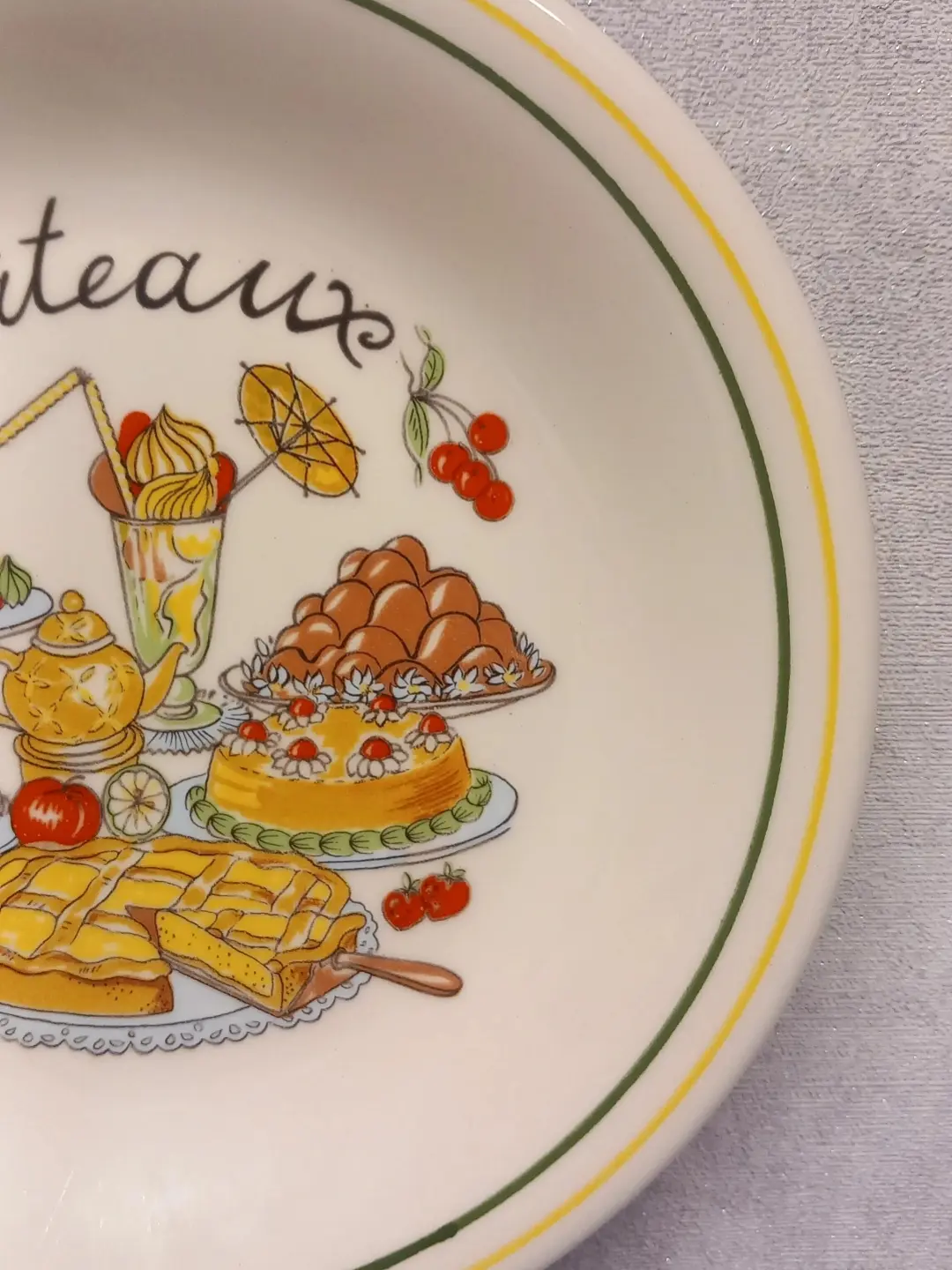 Tabağın sağ yarısı; dondurma kupası, şemsiye süsü, çilekli pasta ve sarı-yeşil kenar çizgileri